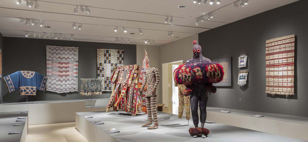 Gallery installation of 'Majestic African Textiles' at Indianapolis Museum of Art showing various narrow strip woven cloths and cultic costume 
