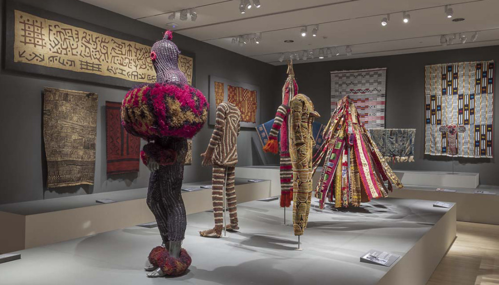 Gallery installation of 'Majestic African Textiles' at Indianapolis Museum of Art showing Central African barkcloth and raffia weaving alongside cultic costume 