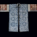 Jacket, China Geija, Early 20th Century. Cuff to cuff and collar to hem: 3' 11" x 2' 8" (119.4 x 81.3cm); Cotton, silk thread; wax resist (batik), embroidery. Long narrow woman's jacket with single front closure at collar, slits at sides and middle back, and wide, elbow-length sleeves. Front and back panels made from wax resist (batik) cotton tabby cloth, sleeves sewn from strips of wax resist dye. Roger Hollander Collection - Primary collection
