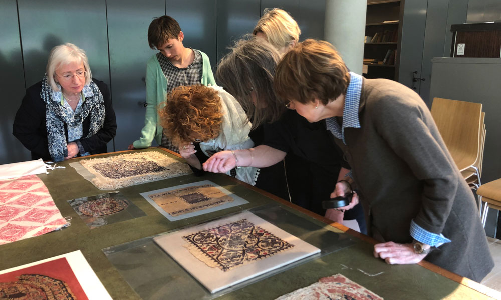 Tour leader Jackie Coulter and Collections Care Manager and Conservator at the Whitworth in Manchester, Ann French show the group Roman Egyptian tunics in the museum stores.