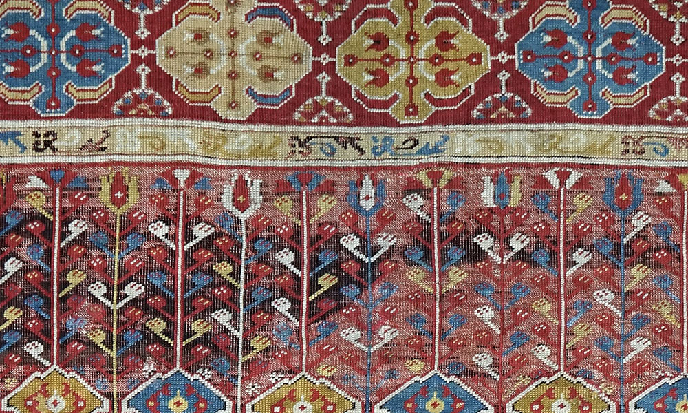 The stylised Ottoman tulips seen here both in the rounded border cartouches and above the trefoils in the additional panel that appears at the top of the rug, between the red-ground spandrels and the main border, are typical of many fine prayer or niche rugs woven in the 17th and 18th century in western Anatolia in centres such as Ushak, Gördes and Kula, as well as in so-called Ladik rugs from slightly further east, when they can appear at either end (or both ends) of the rug, and are sometimes inverted