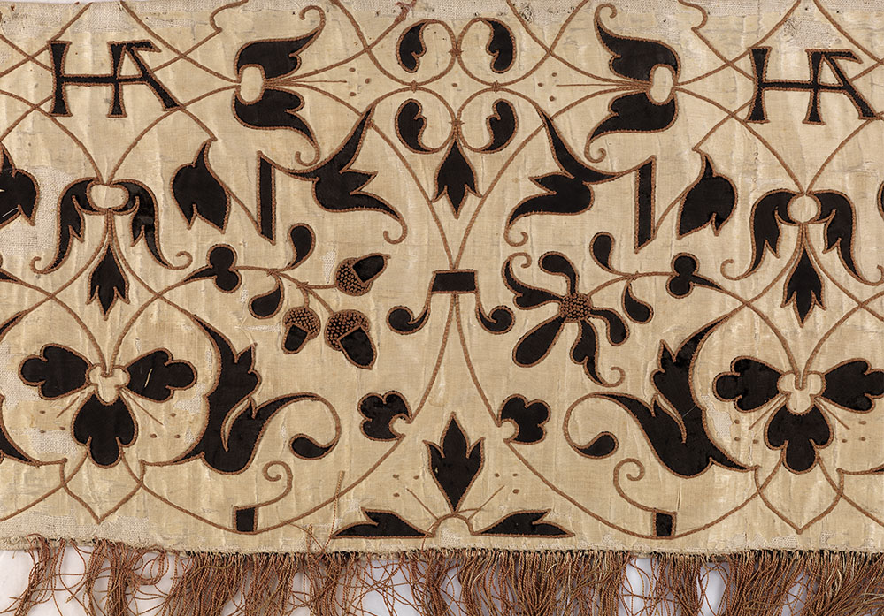 Valance (detail), England, ca. 1532–6. Light cream silk taffeta with linen canvas backing, decorated with arabesque black silk velvet cutwork motifs of acorns