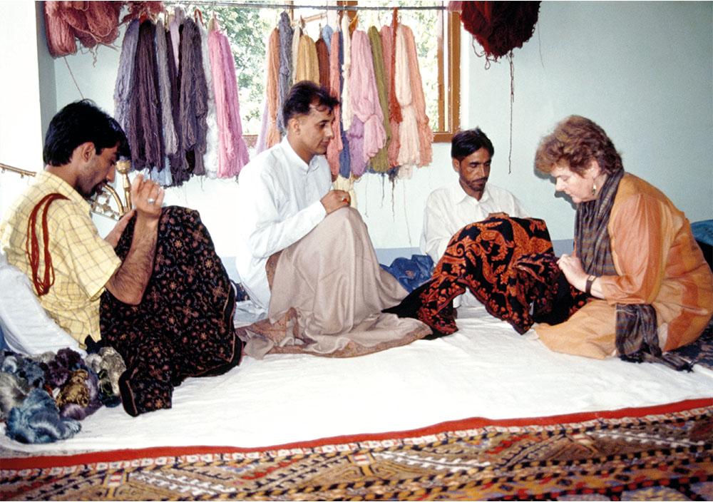 Jenny and Zahid Ali studying a hand-embroidered shawl in a Srinagar workshop